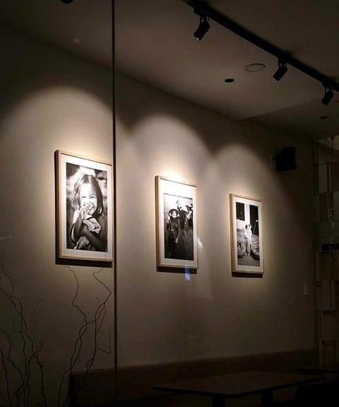 Framed prints lit along the wall at Luna